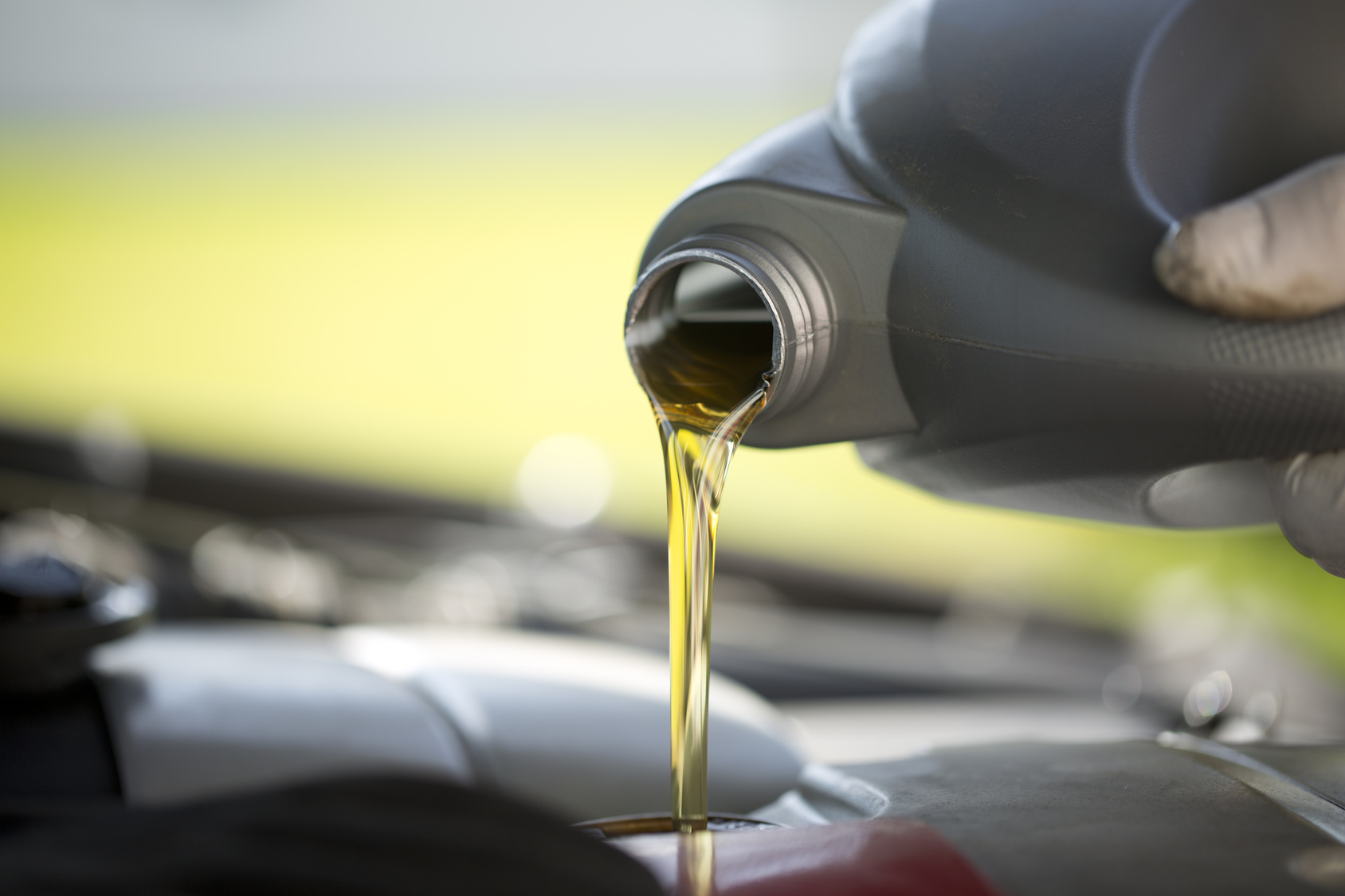 Golden engine oil being poured into a vehicle