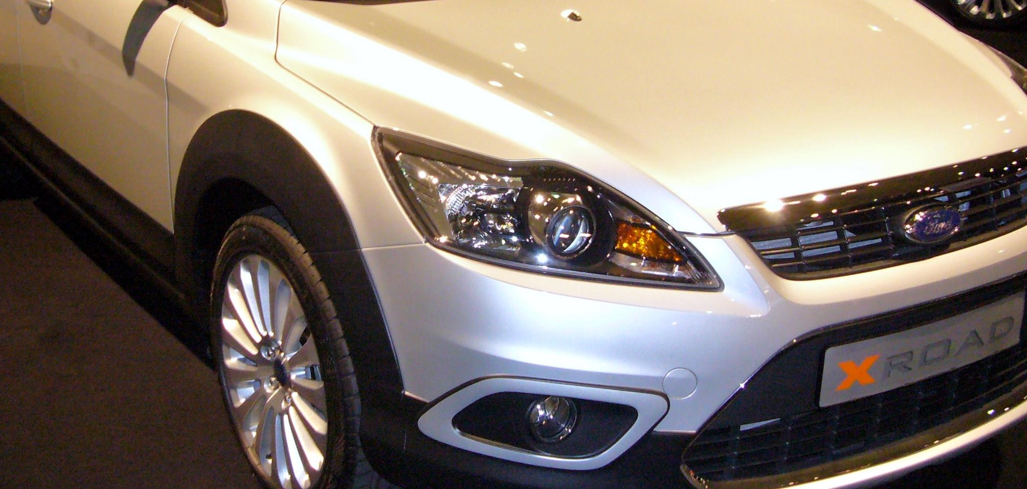 Close-up of a car's headlight and grille, representing AE360 automotive lubricants